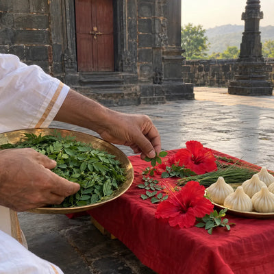 A brass plate heaped with shami leaves offered with hibiscus and modaks