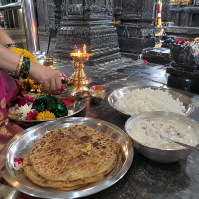 Puran poli and kheer bhog with kunku and a brass samai lamp