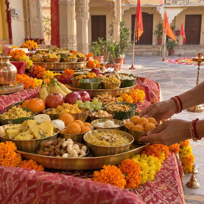 Tiers of sweets, fruits and savouries in brass bowls arranged for a Chhappan Bhog