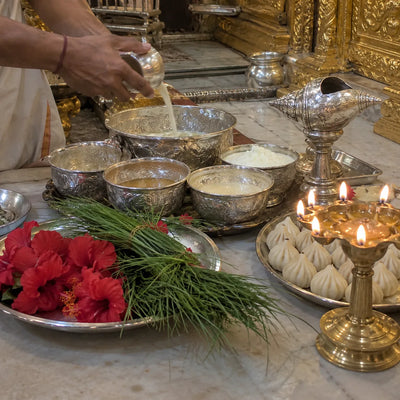 Panchamrut, modaks, durva grass and red hibiscus with an aarti lamp