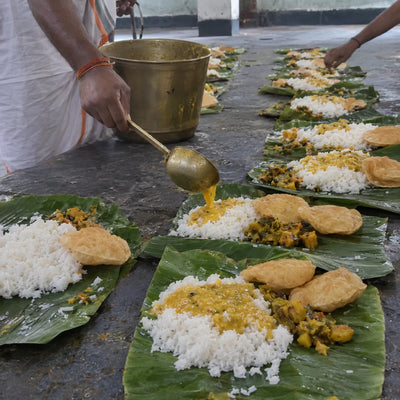Rice, dal and puri served on banana-leaf plates for Daridranarayan bhoj