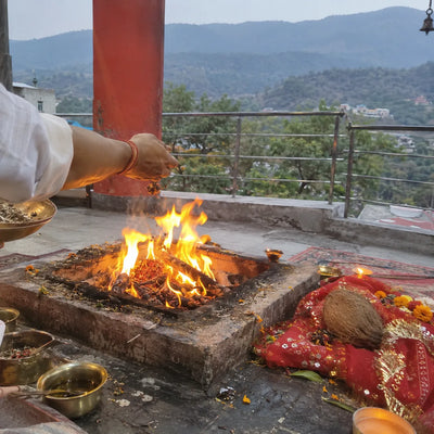 Havan fire with samagri, a red chunri and a coconut, Shivalik hills behind