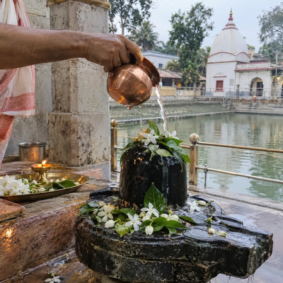 Gangajal poured over a Shivling with bilva leaves and flowers