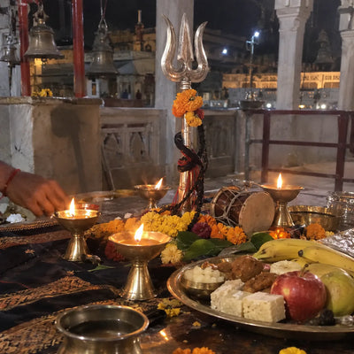 Four oil lamps around a trishul and damru on Kaal Bhairav Jayanti night