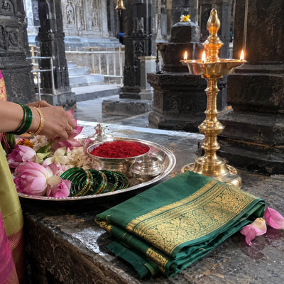 Kunku, green bangles, a silk saree and lotus flowers with a brass samai lamp