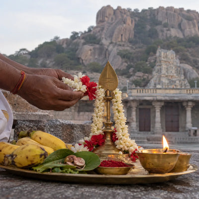 Murugan Archana: flowers, betel leaves and jasmine garlands before a brass vel