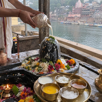 Panchamrit abhishek on a Shivling, the Narmada river behind