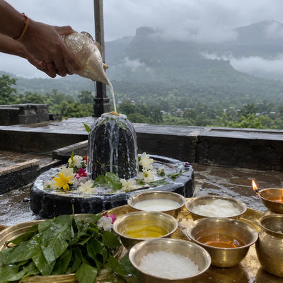Panchamrut abhishek on a Shivling, misty Brahmagiri hills behind