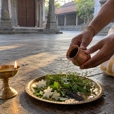 Water offered over tulsi, white flowers and sesame seeds in prayer for ancestors