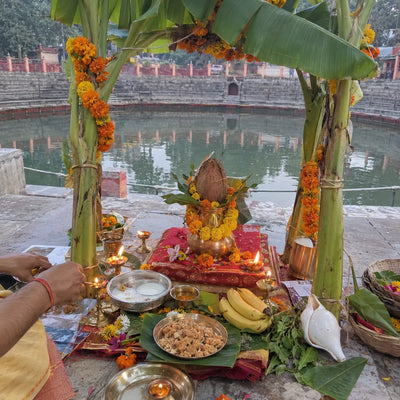 Satyanarayan puja set-up with a banana-stem mandap, kalash and panjiri prasad