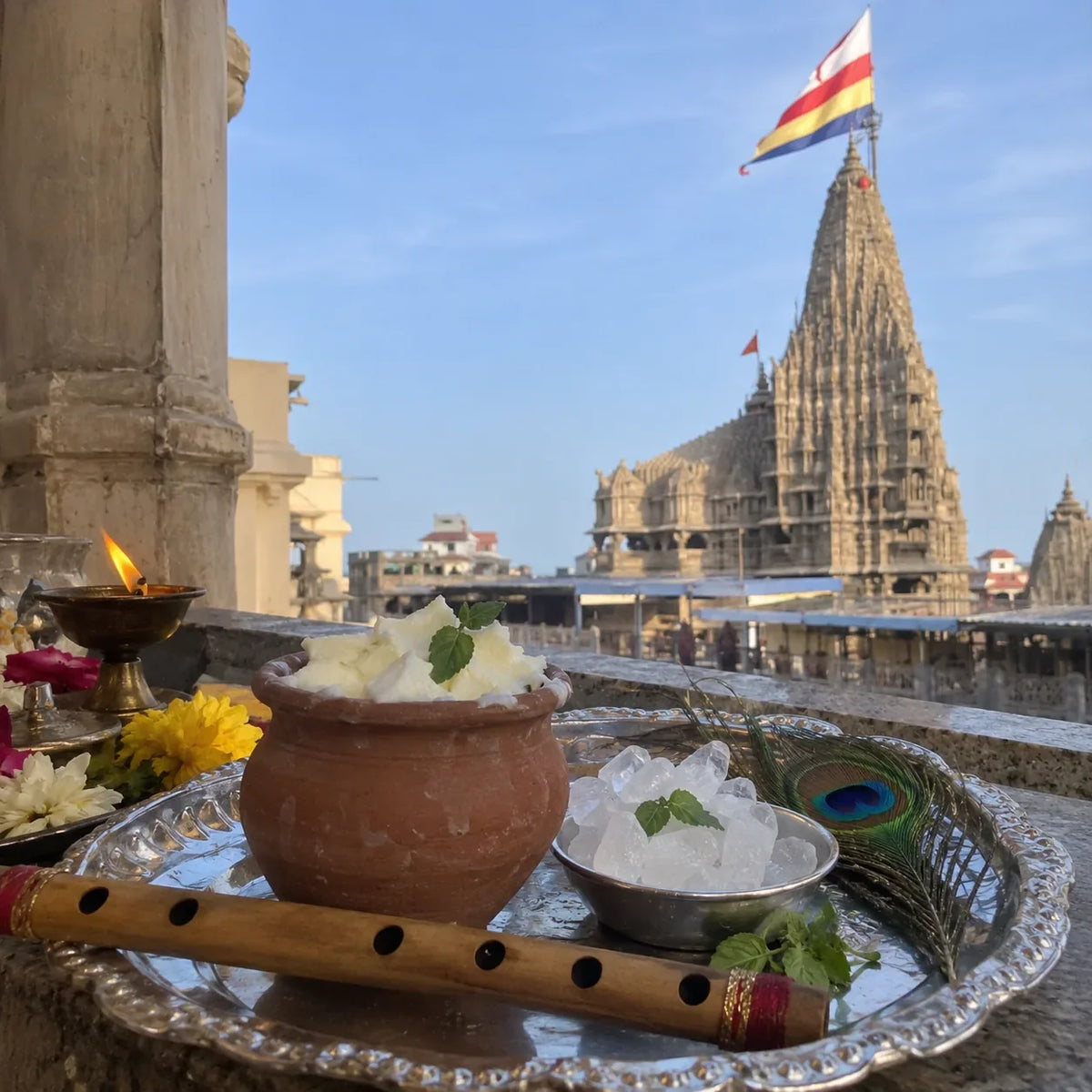 Makhan and misri with tulsi, a flute and a peacock feather, temple flag behind