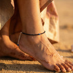 a woman wearing an evil eye anklet
