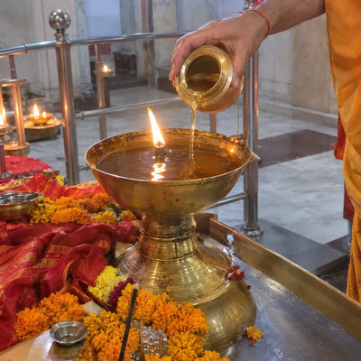 Ghee poured into a large brass akhand jyoti lamp