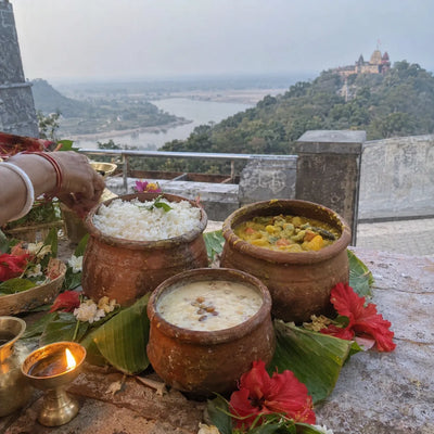 Temple bhog in earthen pots with red hibiscus