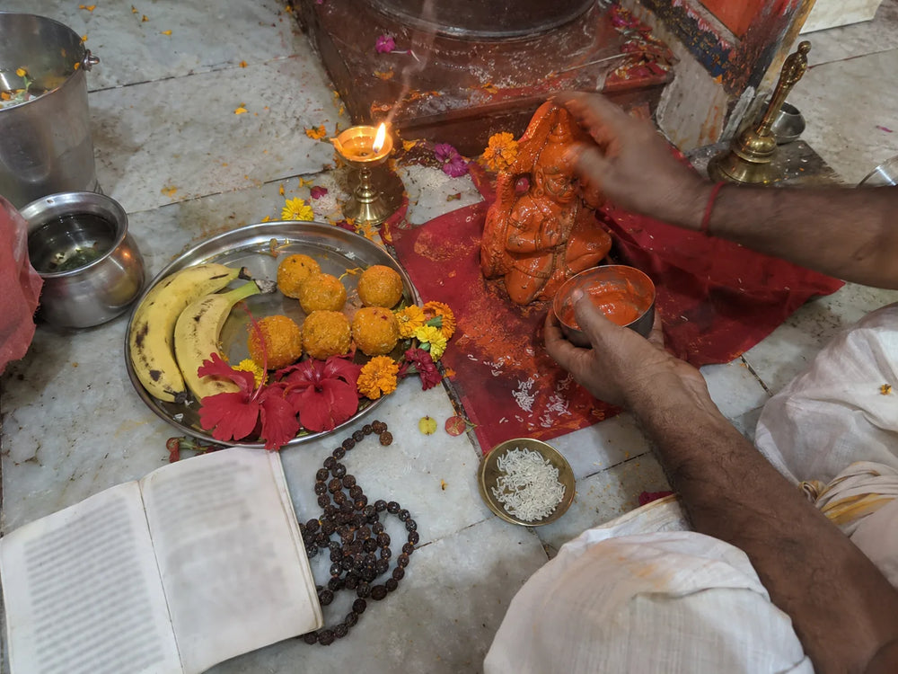 Rog Mukti Hanuman Puja: sindoor offered to Hanuman Ji beside the Hanuman Chalisa, a rudraksha mala and boondi laddoos