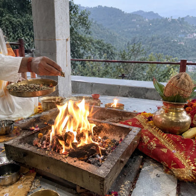 Havan fire with samagri, a red chunri and a coconut, Himachal hills behind