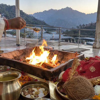 Havan fire with a red chunri, coconut and dry-fruit prasad, mountains behind
