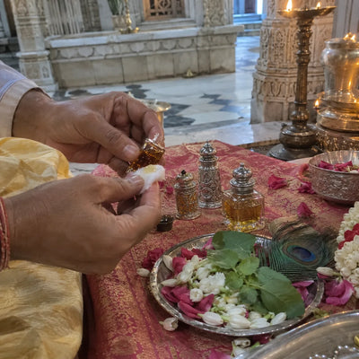 Attar bottles and a cotton phaaha with rose and jasmine petals for itr seva