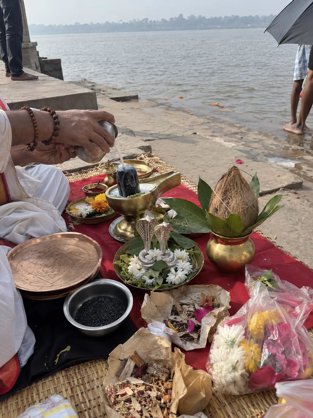 Kaal Sarp Dosh Nivaran Puja: Kaal Sarp puja set up on a river ghat, with the nag-nagin pair, a kalash and offerings