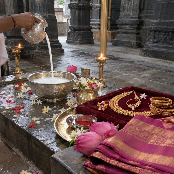 Silver kalash with shringar jewellery, a silk saree and lotus flowers