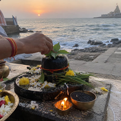 Shivling with a raksha sutra, sesame and a diya for a birthday puja