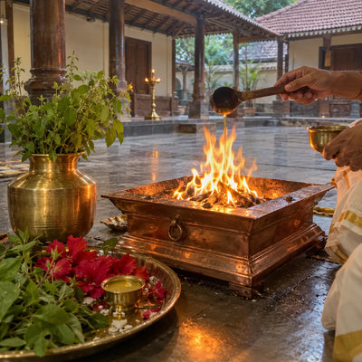 Ghee poured into a havan fire with tulsi leaves and red flowers for a Narasimha yagya