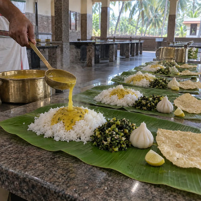 Banana-leaf plates of rice, dal and modak served for annadan