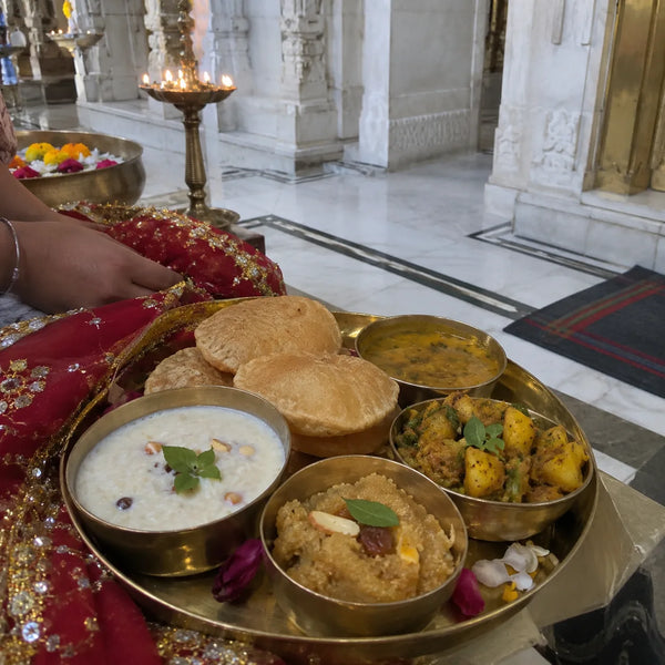 A brass thali of rajbhog with kheer, puri and halwa