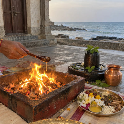 Ghee offered into a havan fire beside a black stone Shivling with bilva leaves