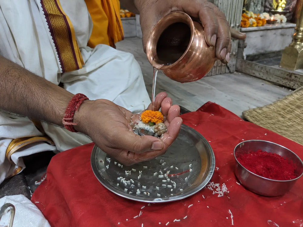 Maa Baglamukhi Puja: the sankalp, water poured into the devotee's palm with flowers and rice