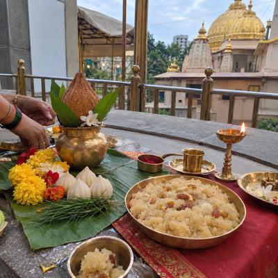 Satya Vinayak puja set-up with a kalash, modaks and sheera prasad