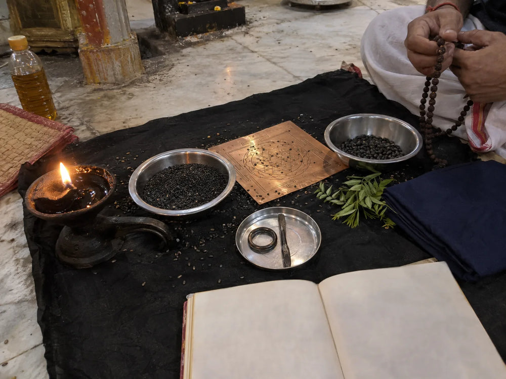Shani Kavach Path: Shani Kavach path set up with black sesame, a til-oil lamp, a rudraksha mala and the open text
