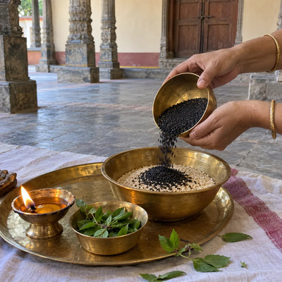 Black and white sesame seeds poured into a brass vessel for til daan
