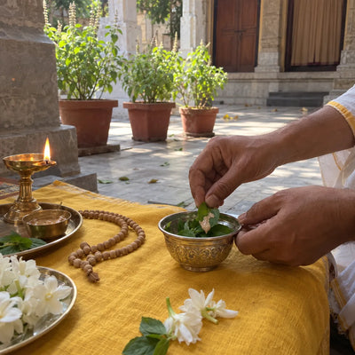 Tulsi leaves with sandalwood paste placed in a silver bowl for a tulsi archana
